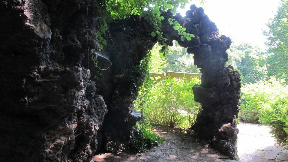 A natural rock archway with a dirt path leading through it.