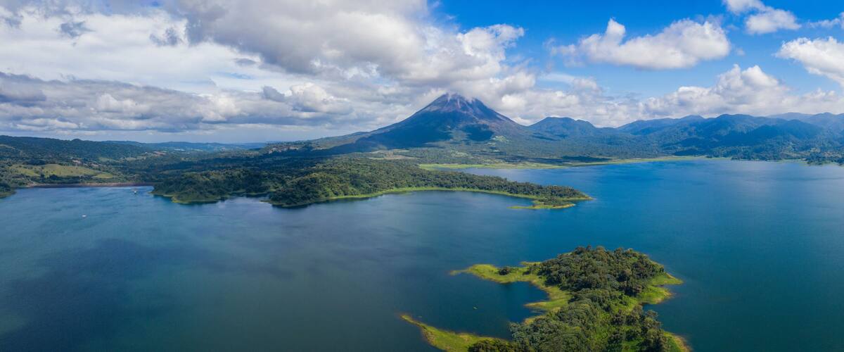 A volcanic mountain, a large lake, and surrounding forested hills.