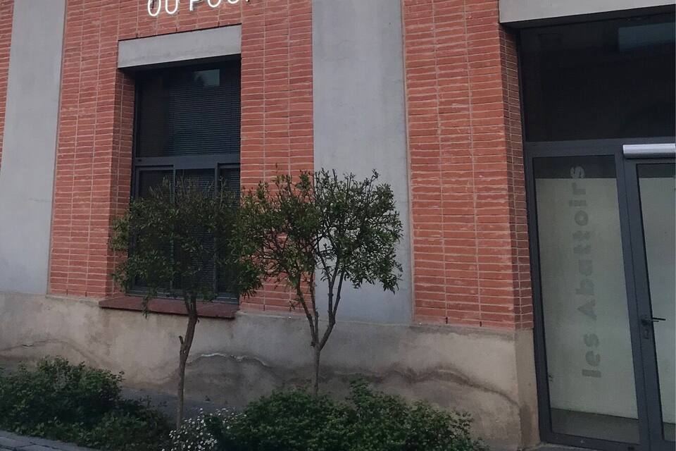 Um edifício com uma placa que diz "LE TEMPS D'UNE RENCONTRE OU POUR TOUS".