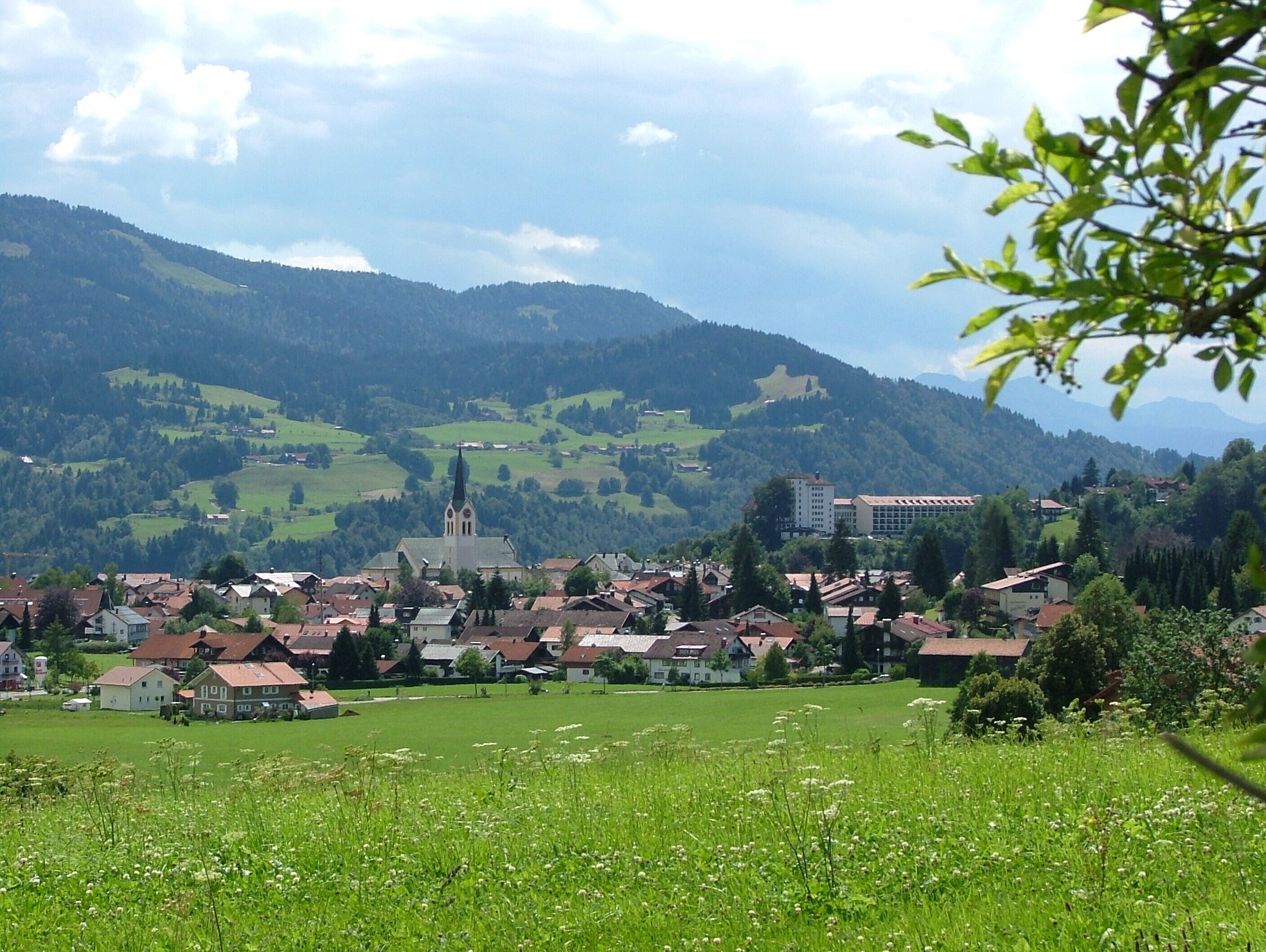 A town nestled in a valley with a prominent church and a castle on a hill.
