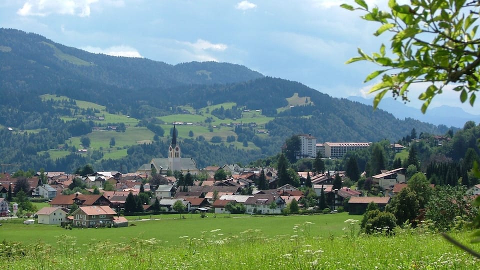 A town nestled in a valley with a prominent church and a castle on a hill.