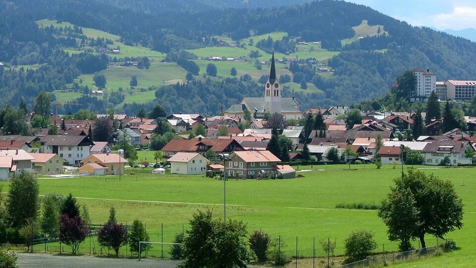 A town with a prominent church, surrounded by green fields and hills.
