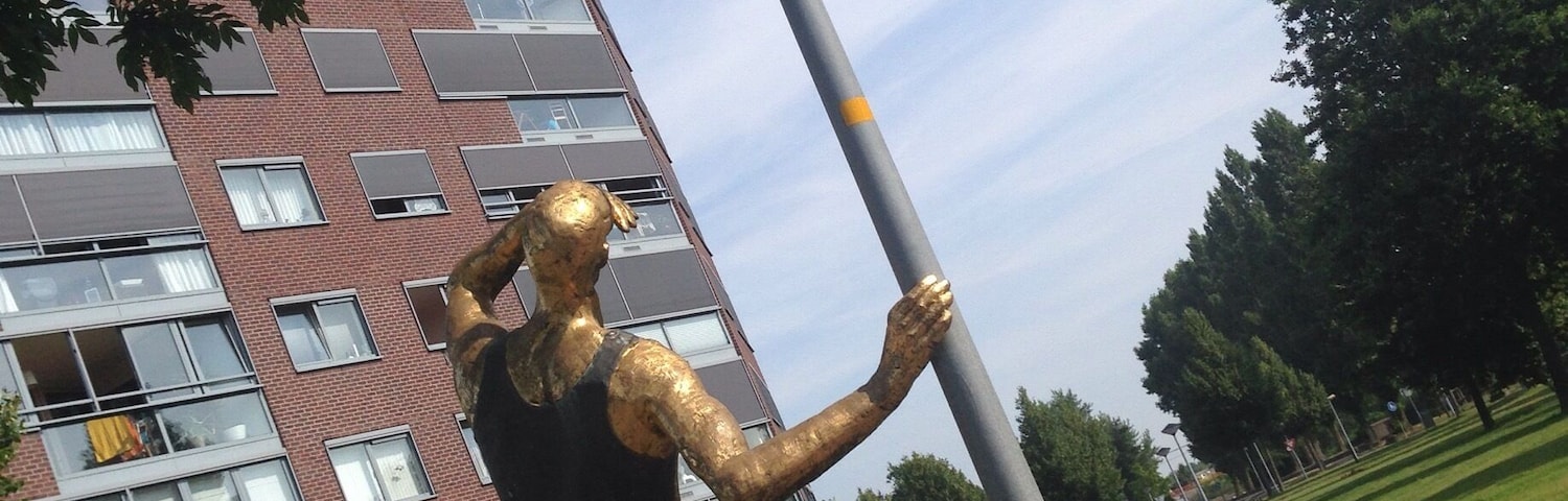 "Golden Man" by André Havas. I guess it would be a bit awkward to have a statue stare at your apartment, but one apparently does get used to it. http://www.flevolanderfgoed.nl/home/kunst/zuidelijk-flevoland/almere/de-gouden-man.html