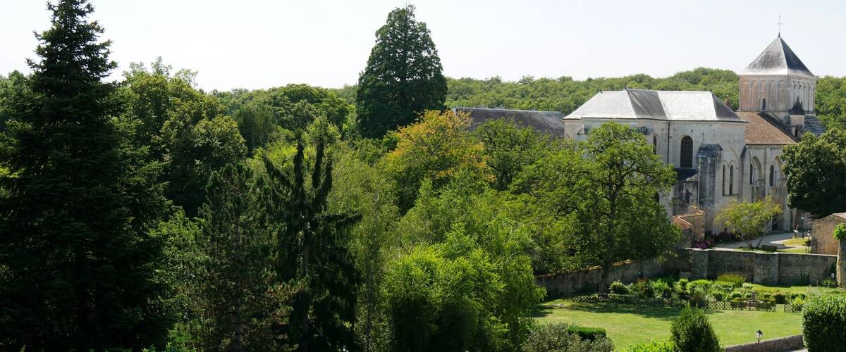 A historic town with a prominent church, stone buildings, and lush greenery.
