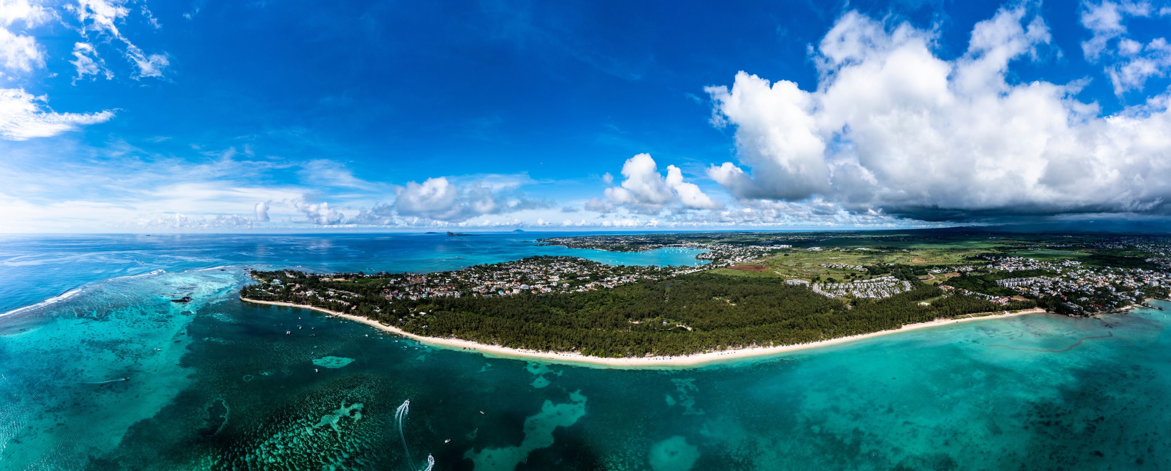 Una isla tropical con aguas turquesas cristalinas, una playa arenosa y vegetación verde exuberante.