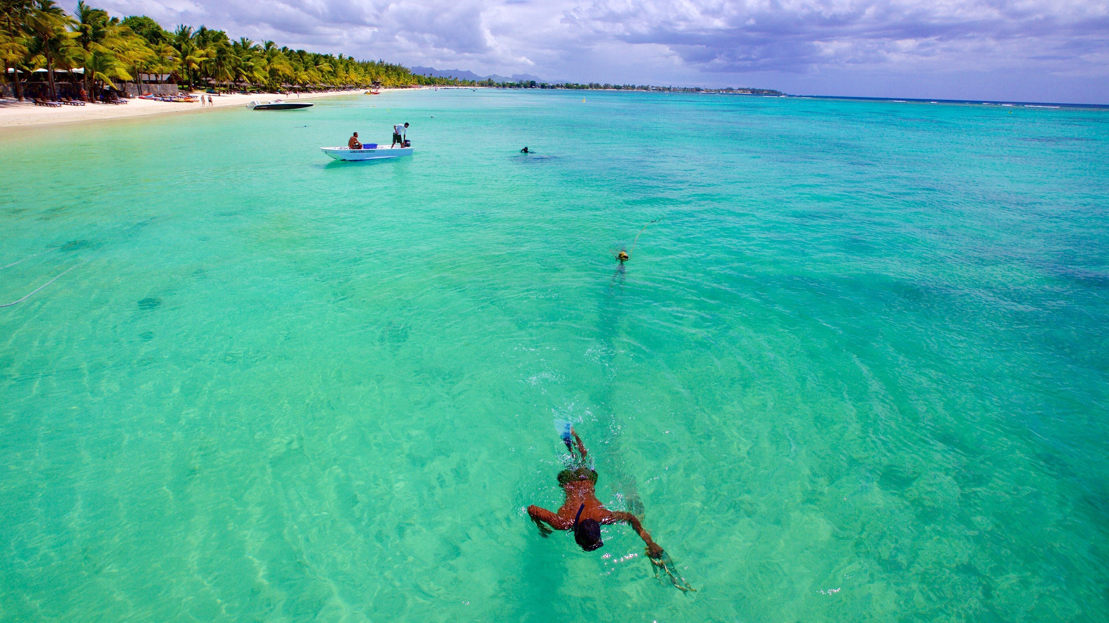Trou aux Biches featuring boating and a sandy beach as well as an individual male