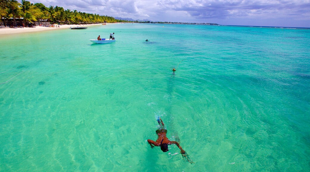 Trou aux Biches featuring boating and a sandy beach as well as an individual male