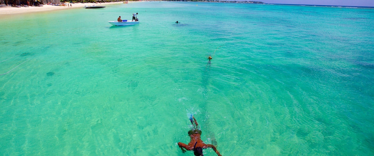 Trou aux Biches featuring boating and a sandy beach as well as an individual male