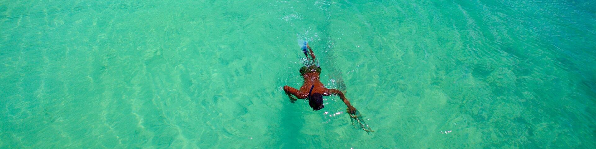 Trou aux Biches featuring boating and a sandy beach as well as an individual male