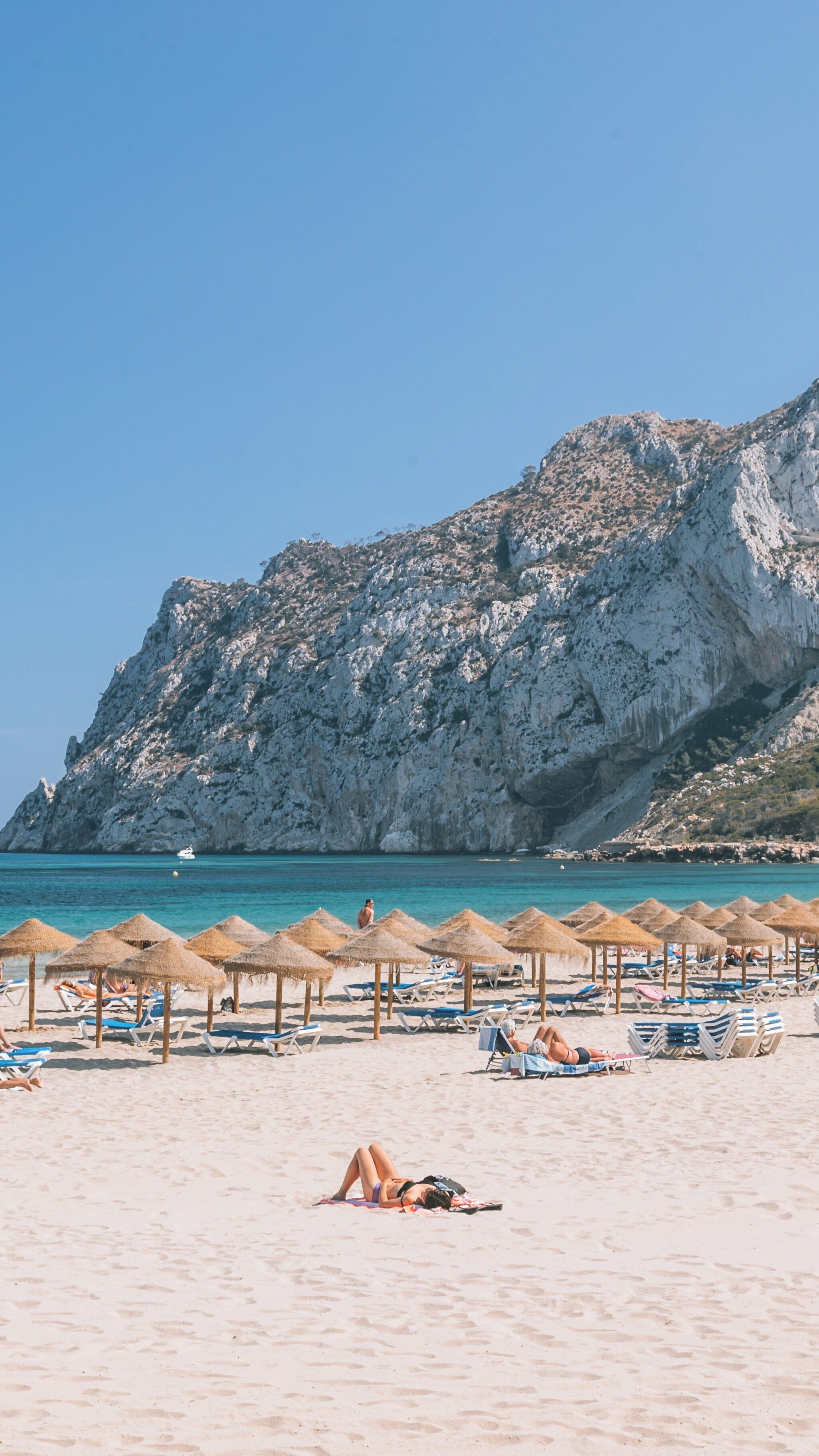 Enjoying the sun at La Fossa Beach in Calpe Spain, a vibrant destination with stunning cliffs and inviting turquoise waters