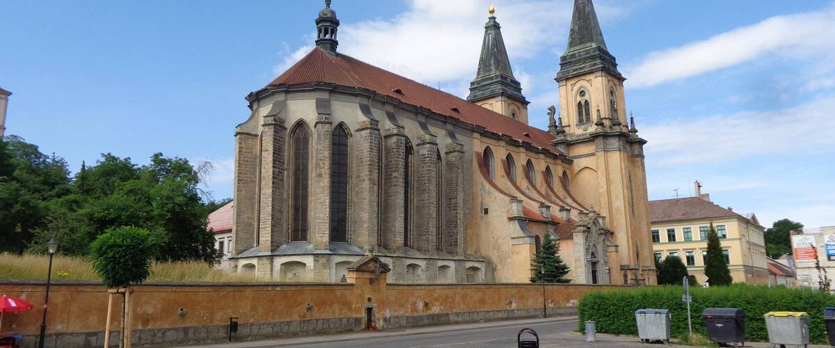 A historic church with two towers and a red-tiled roof.