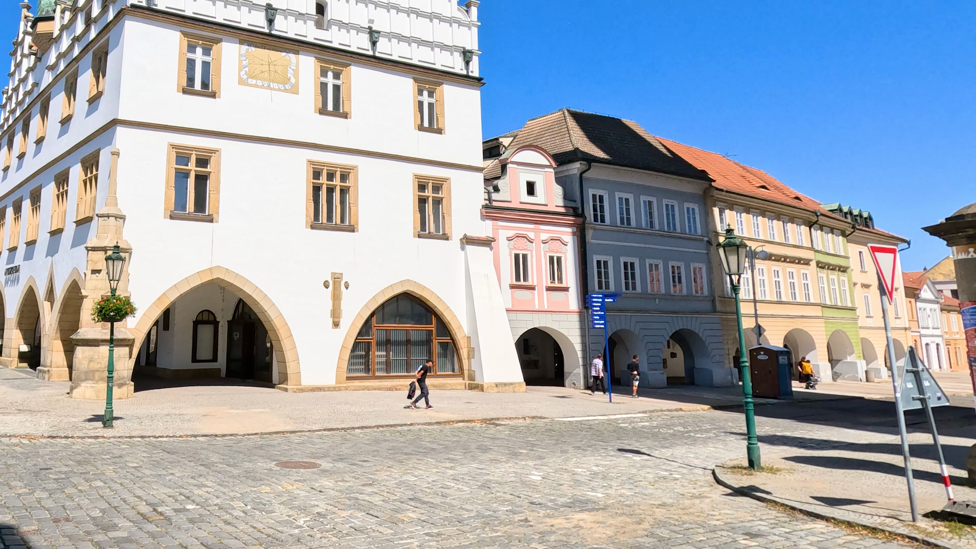 Man Walking Past Historic Town Hall in Litomerice Square