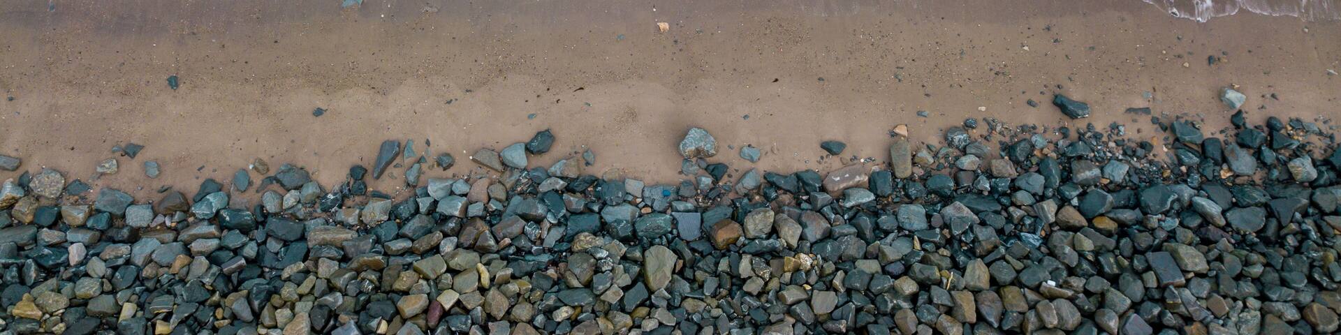 A beach with a rocky shoreline and waves approaching the shore.