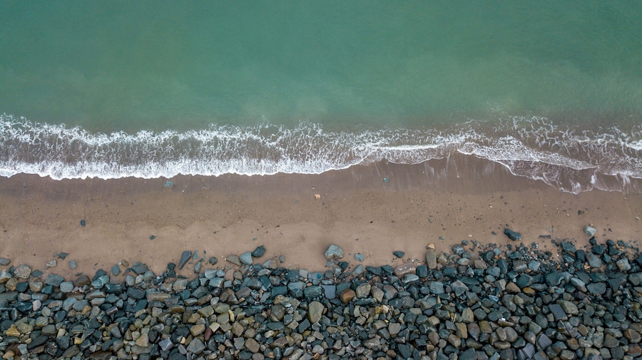 A beach with a rocky shoreline and waves approaching the shore.