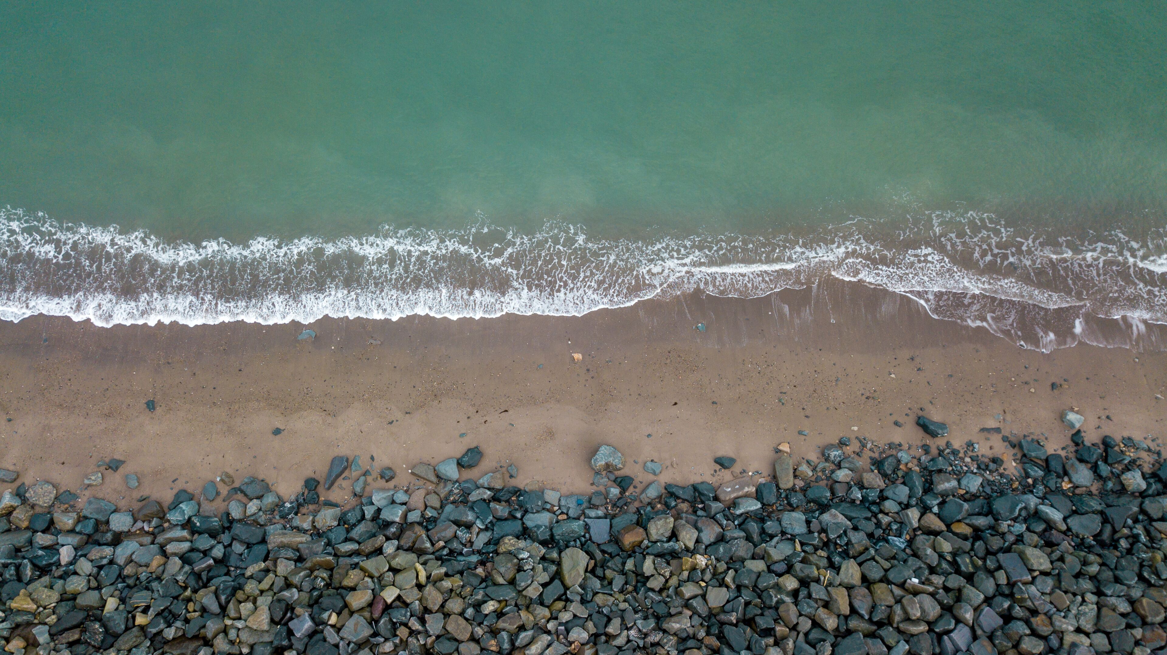 A beach with a rocky shoreline and waves approaching the shore.