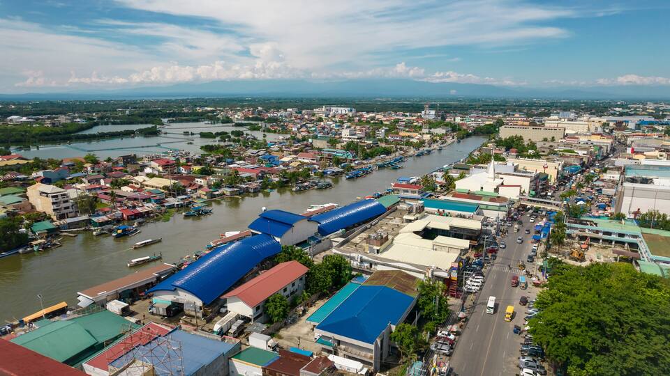 A river running through a city with boats, buildings, and a bridge.