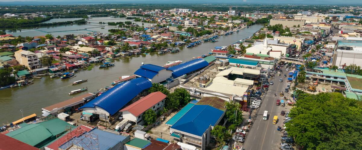 A river running through a city with boats, buildings, and a bridge.