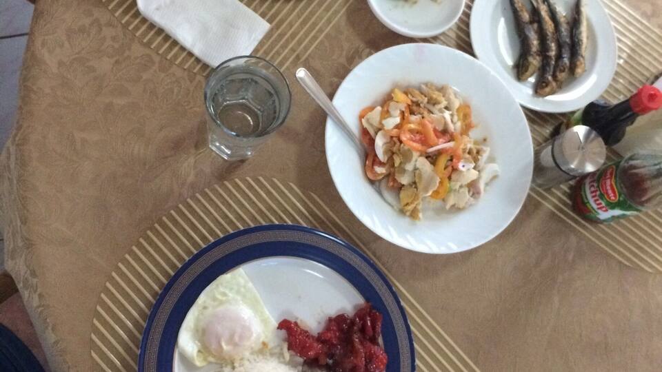 A table with various dishes including rice, eggs, and fish.