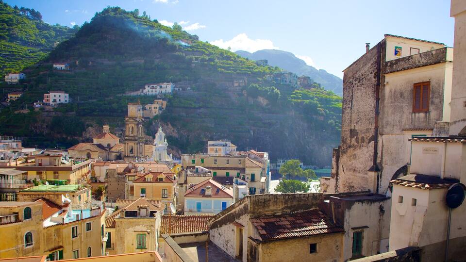 A coastal town with terraced houses, a church, and a mountain in the background.