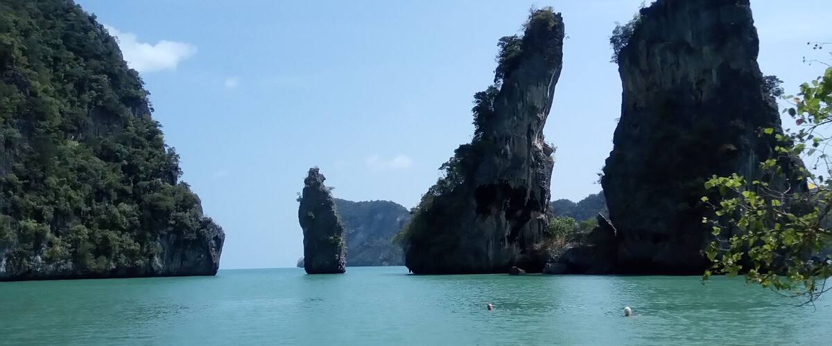 A coastal landscape with prominent limestone karsts and calm turquoise waters.