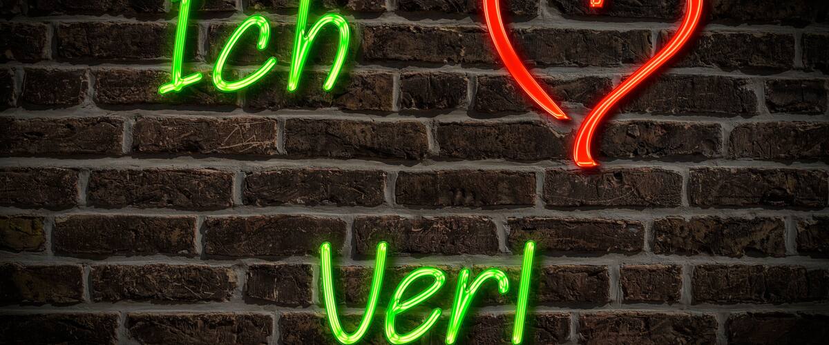 A brick wall with neon signs spelling "Ich Verla" and a red heart.