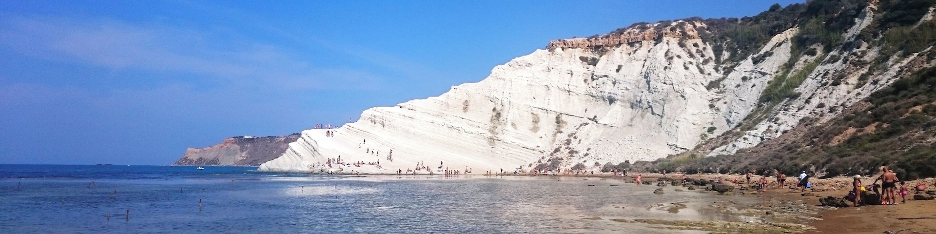 Uma praia costeira com falésias brancas e água azul cristalina.