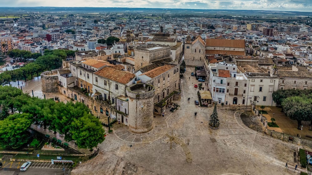 Une ville historique, caractérisée par une tour imposante, des rues pavées et une grande place publique.