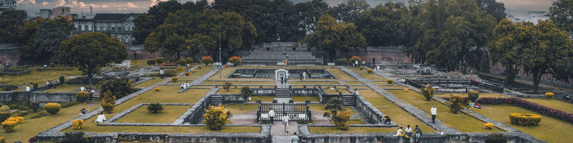 Un jardín grande y formal con senderos simétricos y un edificio central.