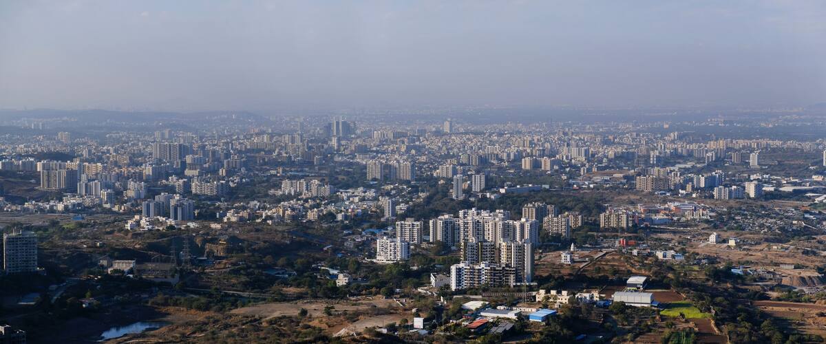 A densely populated urban area with numerous high-rise buildings and scattered green spaces.