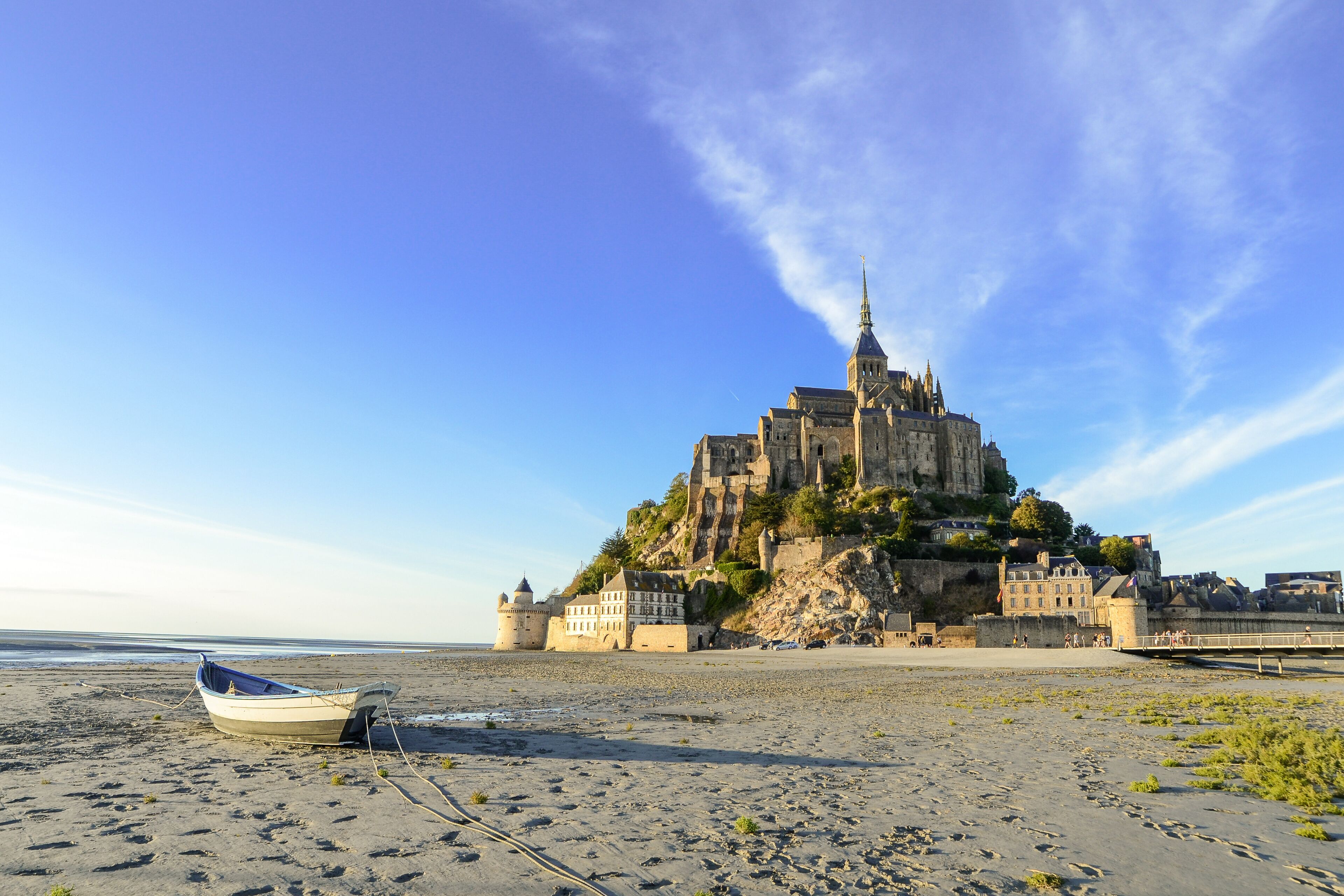 Un castillo costero en un acantilado, con una playa al frente.