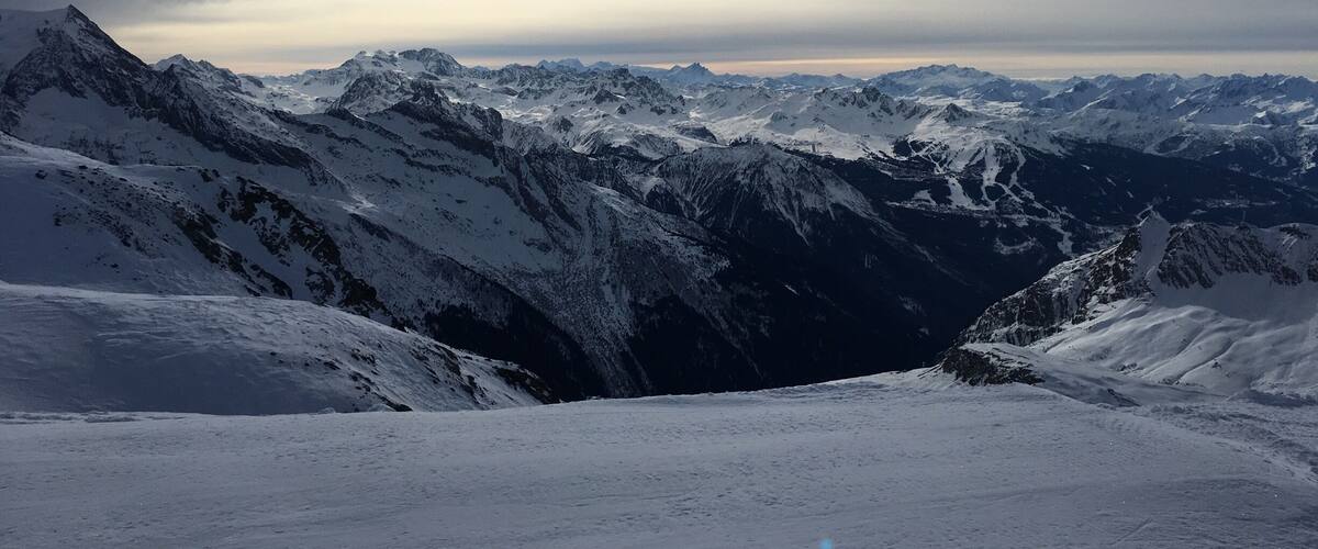 A snow-covered mountain range with rugged peaks and a valley.