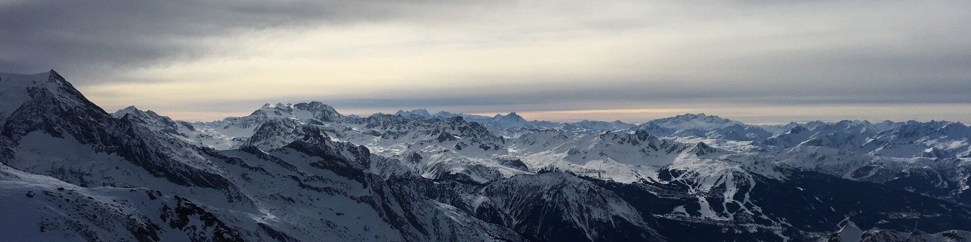 A snow-covered mountain range with rugged peaks and a valley.