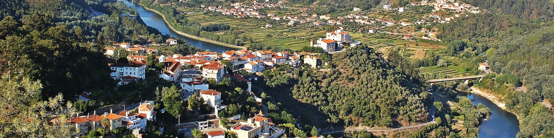 A river winding through a valley with a town on the hillsides.