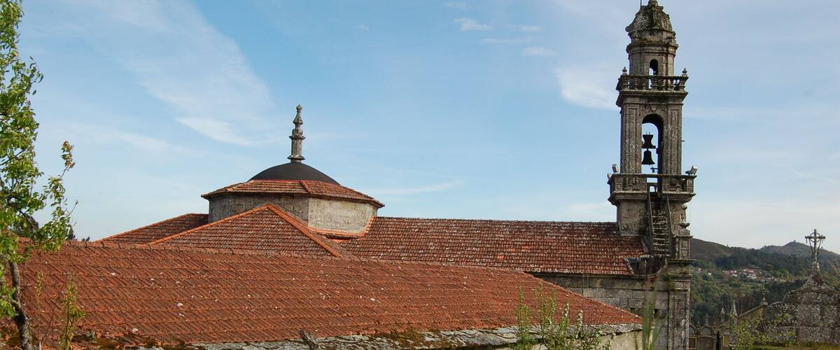 A historic church with a bell tower and a red-tiled roof.