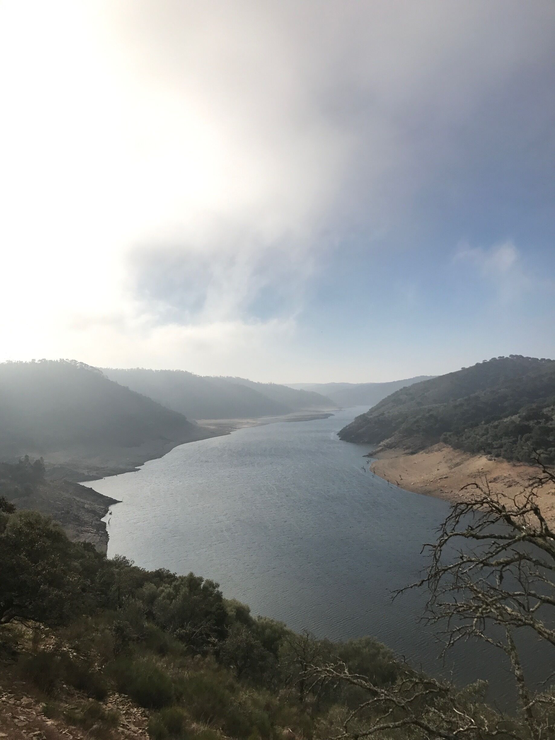 A river winding through a valley with hills on either side.