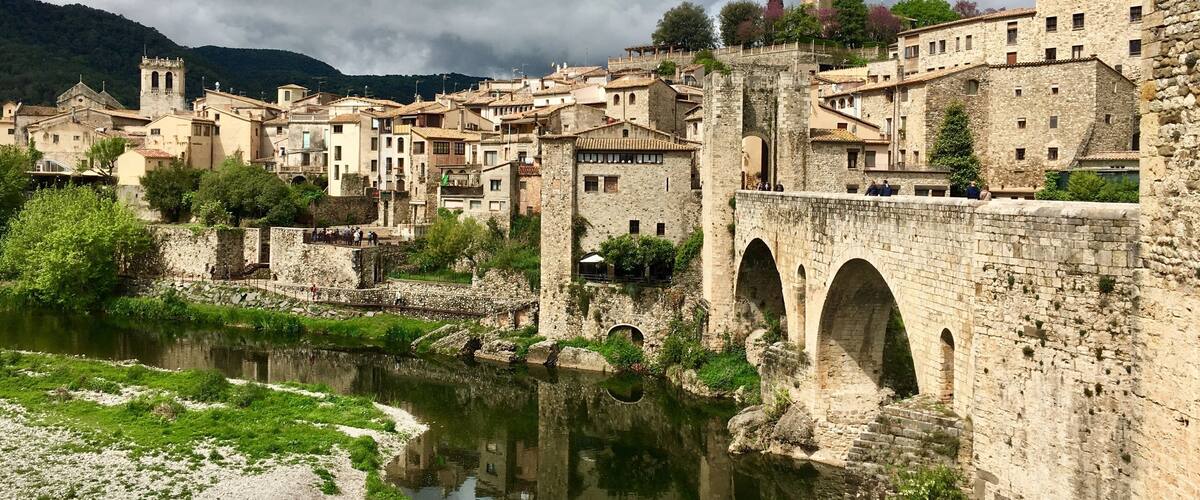 Eine historische Stadt mit Steinhäusern, einem Fluss und einer Brücke.