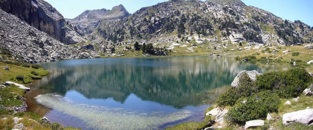 A mountain lake surrounded by rocky terrain and sparse vegetation.