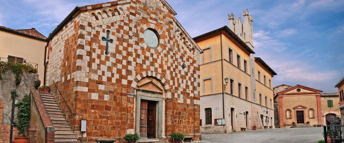 A historic church with a checkered facade and a bell tower.
