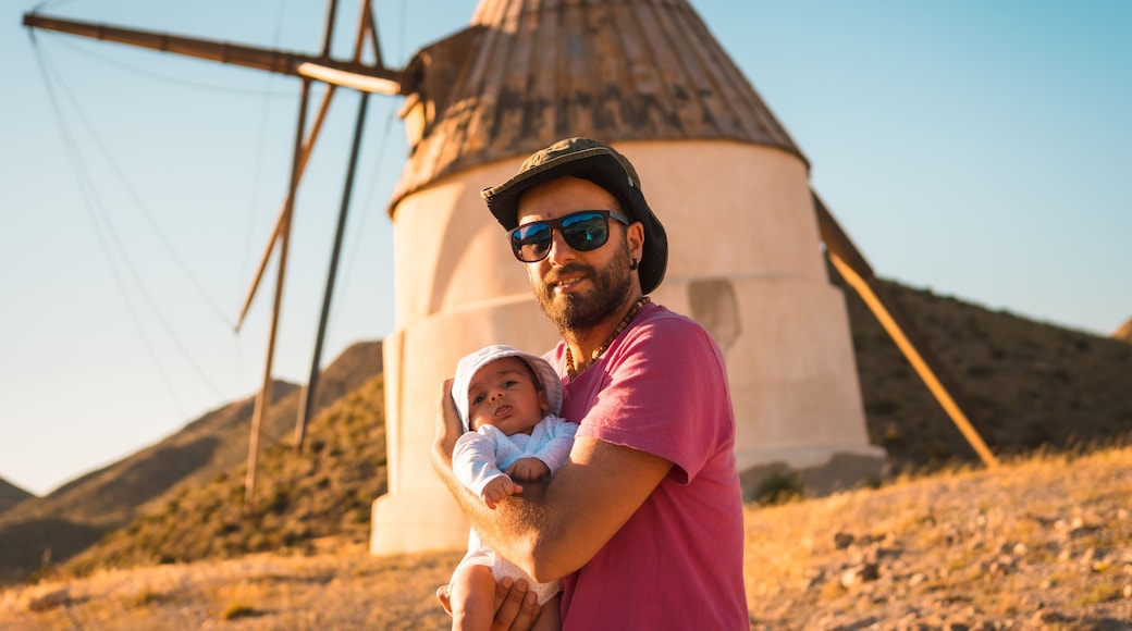 A young man enjoying with his son in the Natural Park of Cabo de Gata, a mill in the town of San Jose, Almeria. Spain