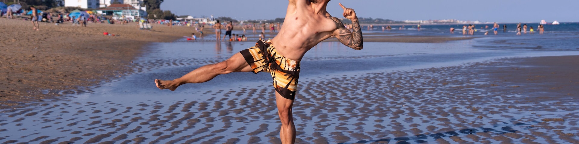 A beach with a person performing a kick.