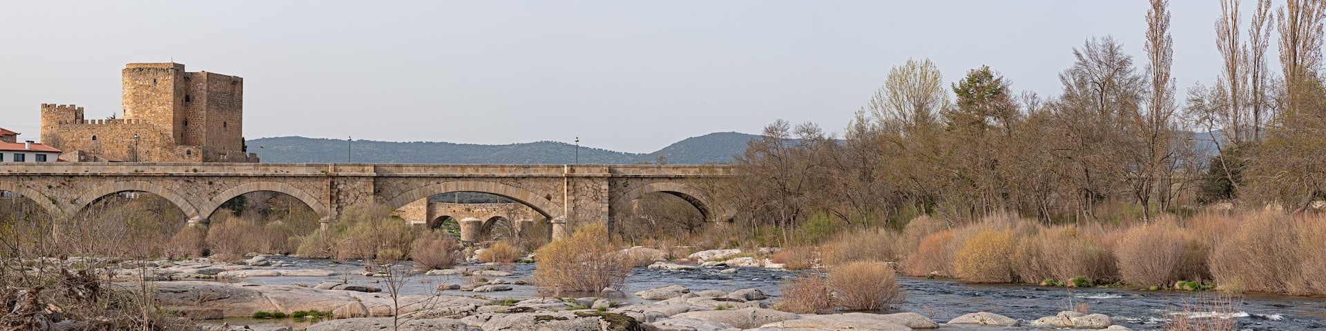 Congosto and medieval bridge with Castillo de los Dávila with the Tormes river in Guijuelo, Salamanca, Spain
