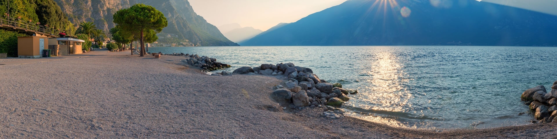 A pebble beach with a mountain backdrop and a clear sky.