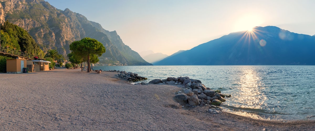 A deserted beach in Limone on Lake Garda. Sunrise over the mountains. tourist resort italy
