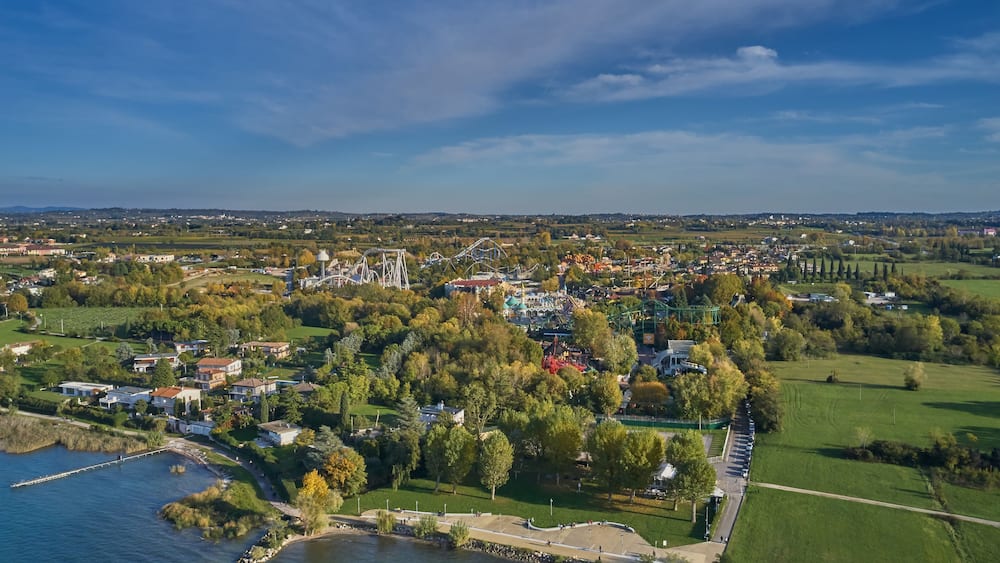 An aerial view of a lakeside town with a park, amusement park, and residential area.