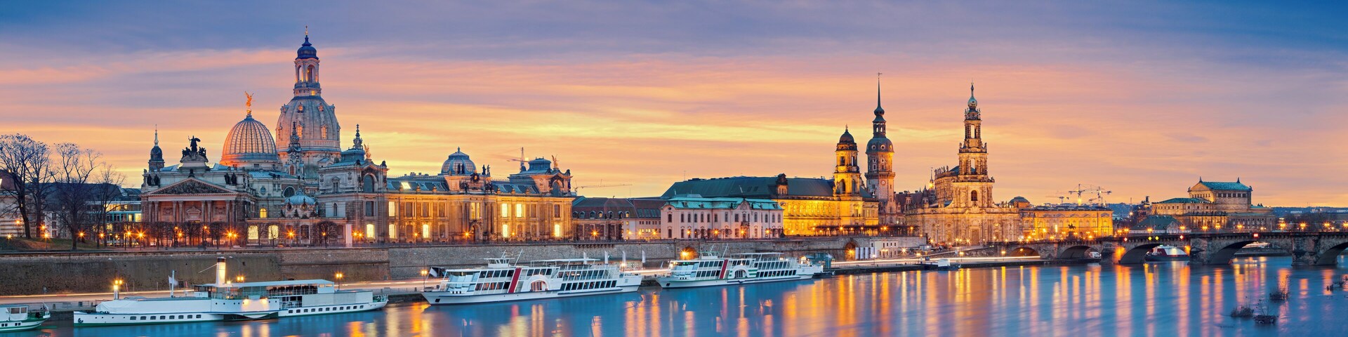 Panoramic image of Dresden, Germany during sunset with Elbe River in the foreground. This is composite of two horizontal images stitched together in photoshop.