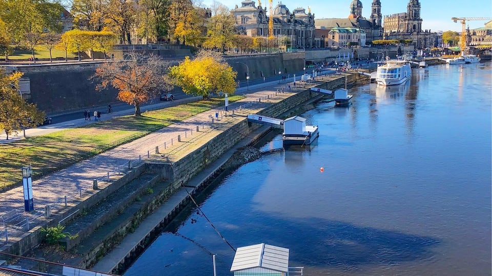 Une rivière avec des bateaux, un pont et, au loin, des bâtiments historiques.