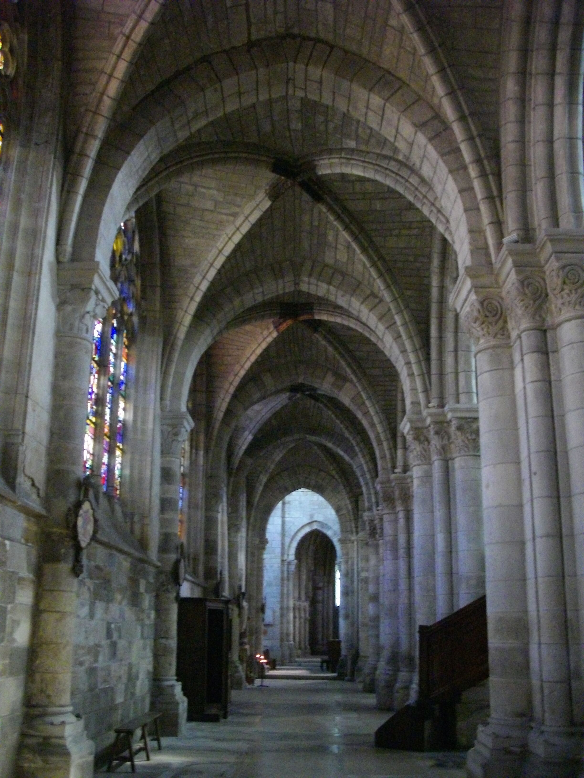 A cathedral nave with arched ceilings and stained glass windows.