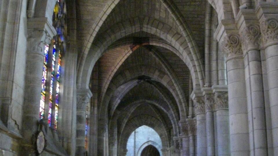 A cathedral nave with arched ceilings and stained glass windows.