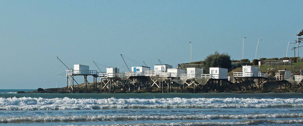 A coastal area with fishing structures and a lighthouse.