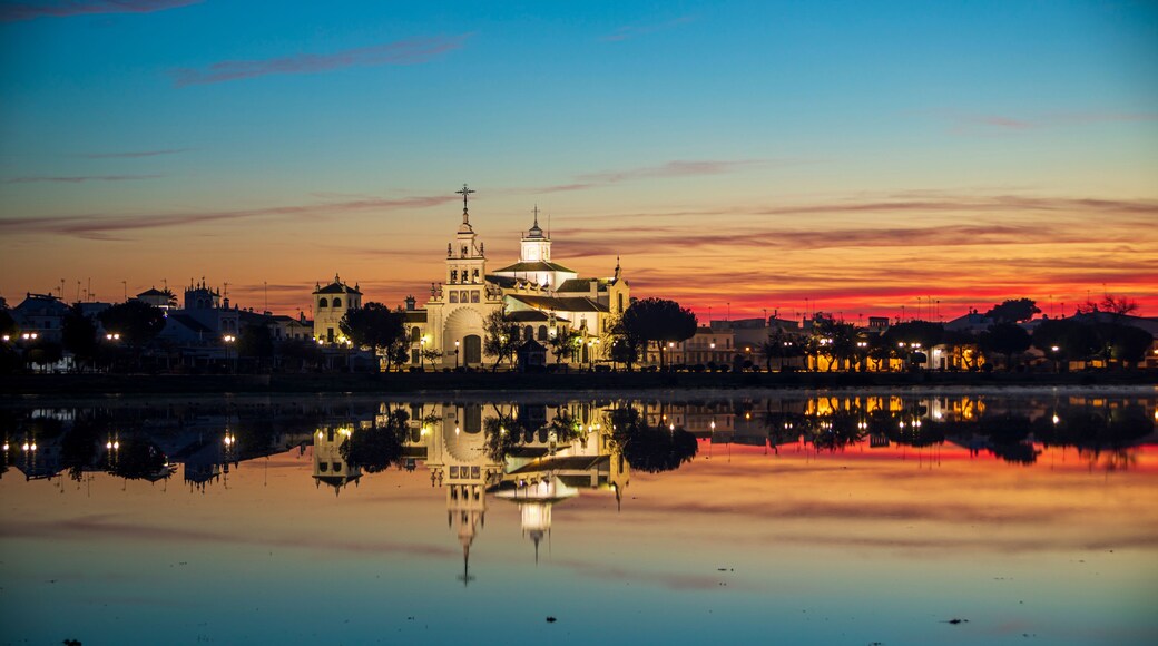 Landscape at dawn of the village and hermitage of El Rocío in Huelva, Spain, reflected in the calm waters of a lake